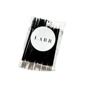 Clear plastic package of eyelash spoolies and lipstick applicators with a white LABB sticker on the outside of the package. 